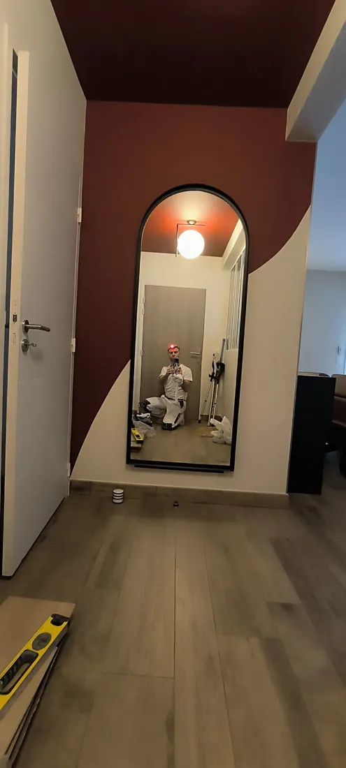 Arche peinte autour d'un miroir dans une entrée