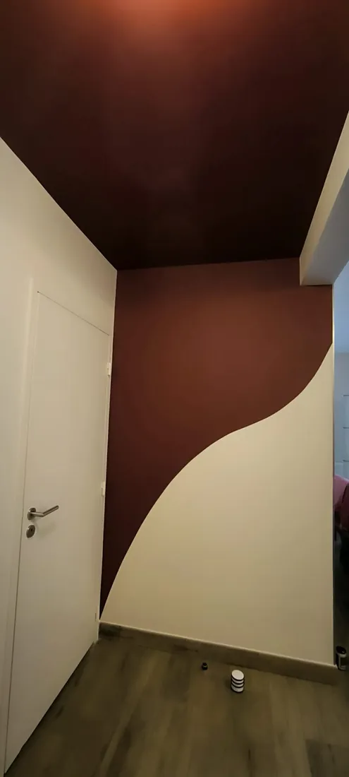Mur et plafond peints en bordeaux avec une courbe